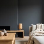 Mur en gris anthracite dans un salon chaleureux avec meubles en bois clair et textiles doux