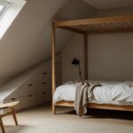 Chambre mansardée aménagée avec lit sous la pente et rangements sur mesure sous le toit