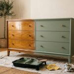 Commode ancienne moitié vernie moitié repeinte en vert sauge avec rouleau et pinceau